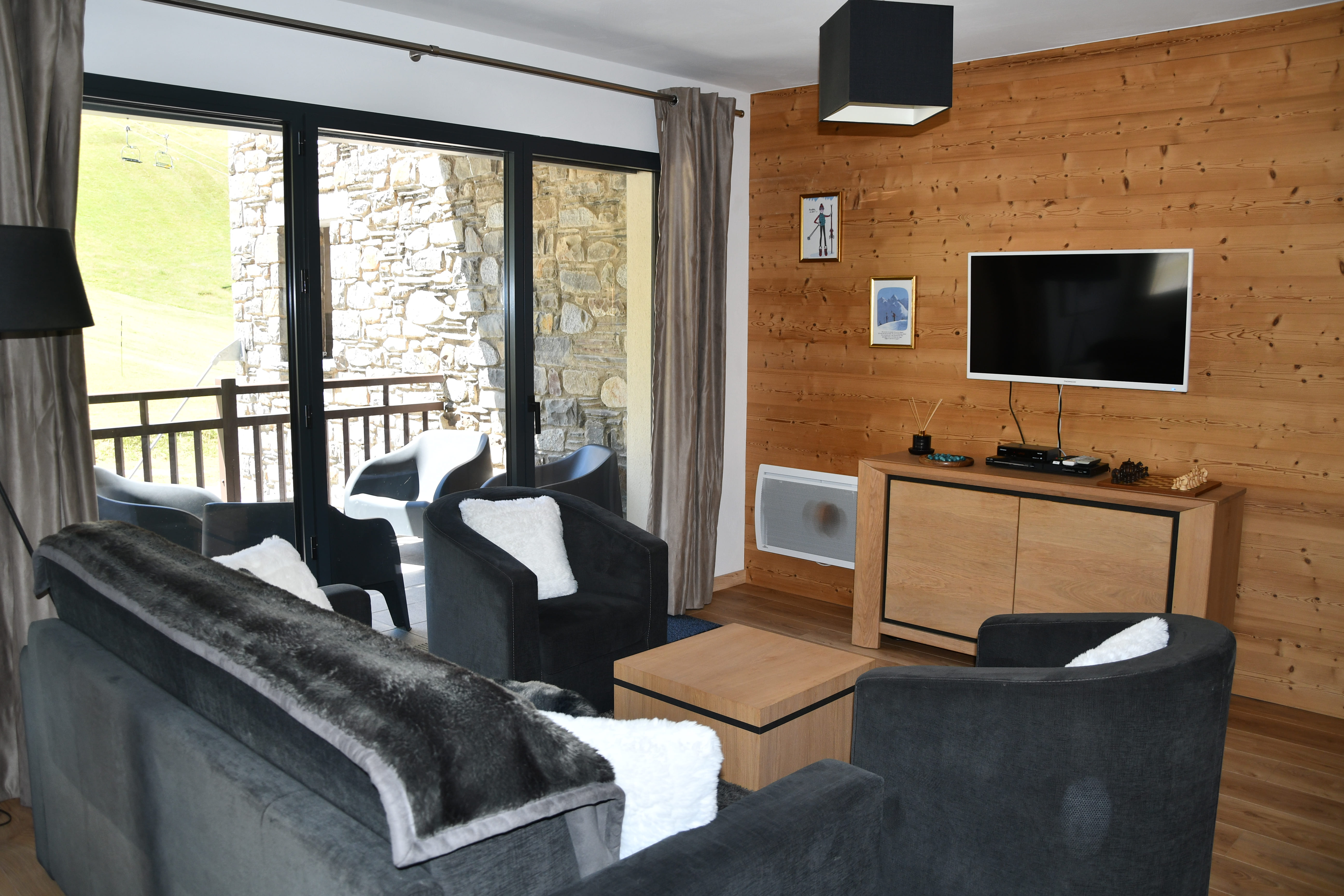 Salon avec TV et mur en bois